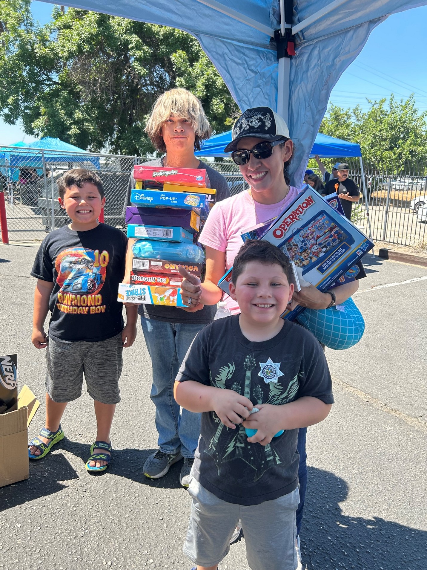 Three boys and their mother pose with donated toys.