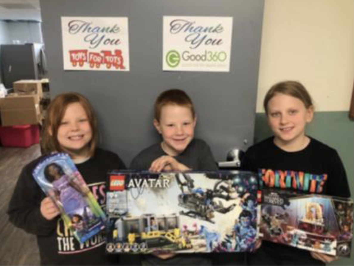 Children pose with new toys donated from a collaboration with Toys for Tots and Good360.